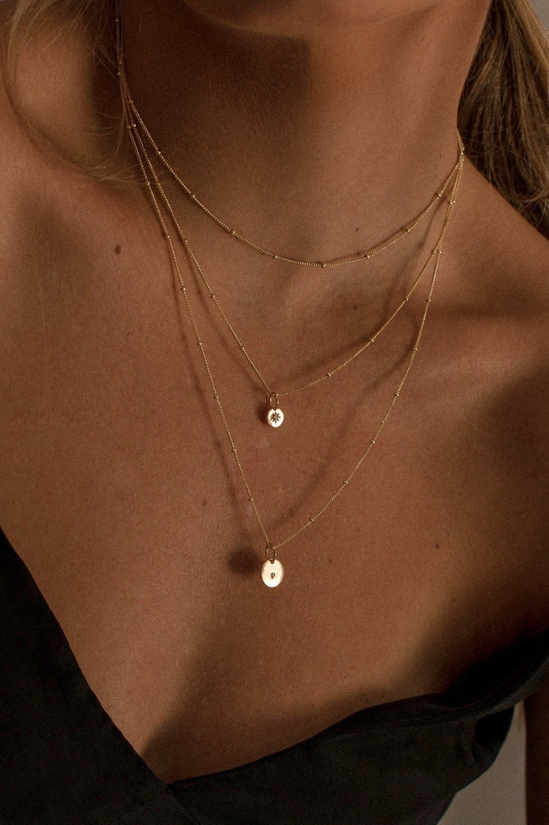 Model wears Ball Chain Necklace, Vintage Pearl Necklace and Ball Chain Necklace with Initial Pendant.