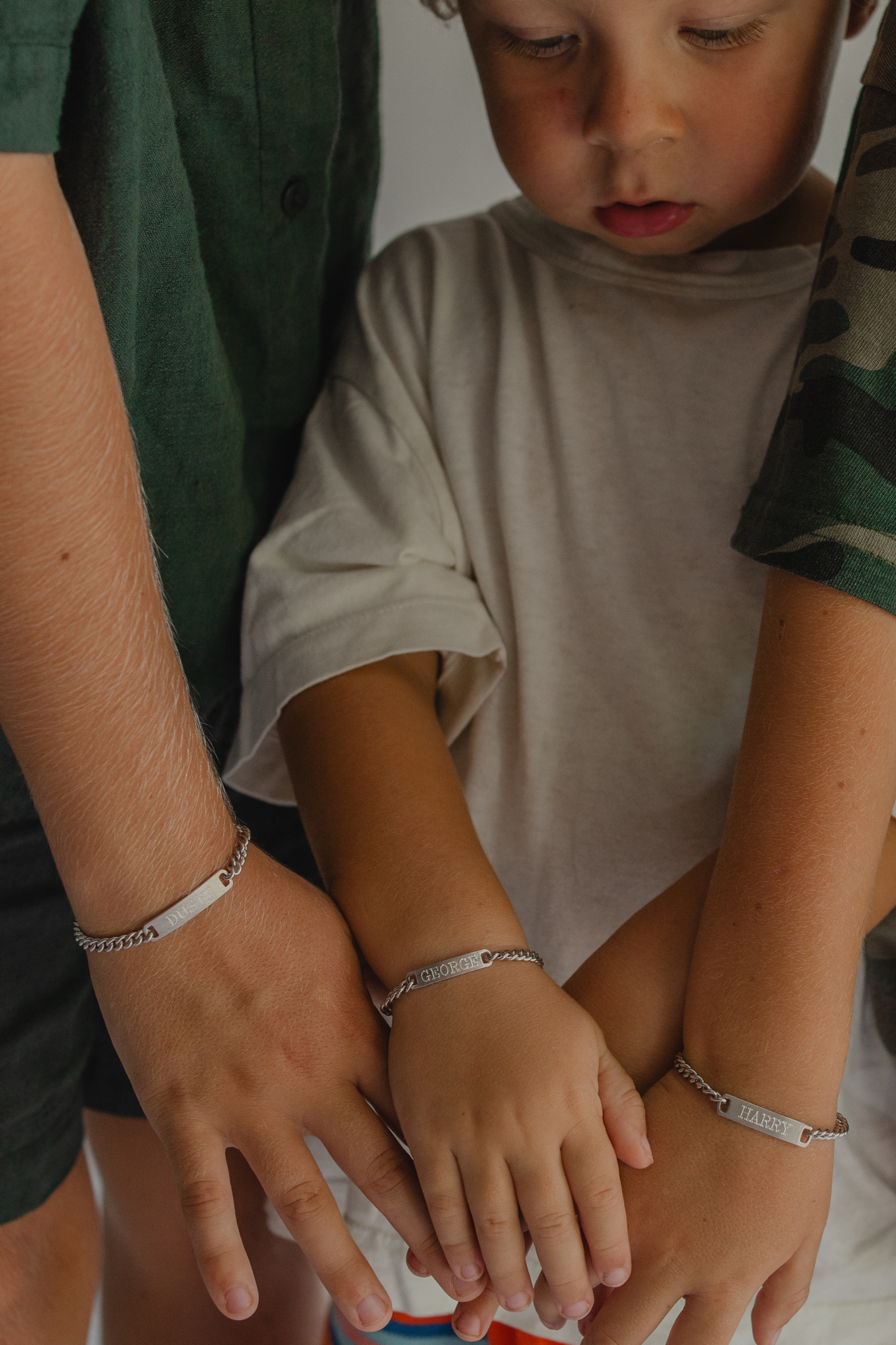 Three brothers wear matching ID bacelets.