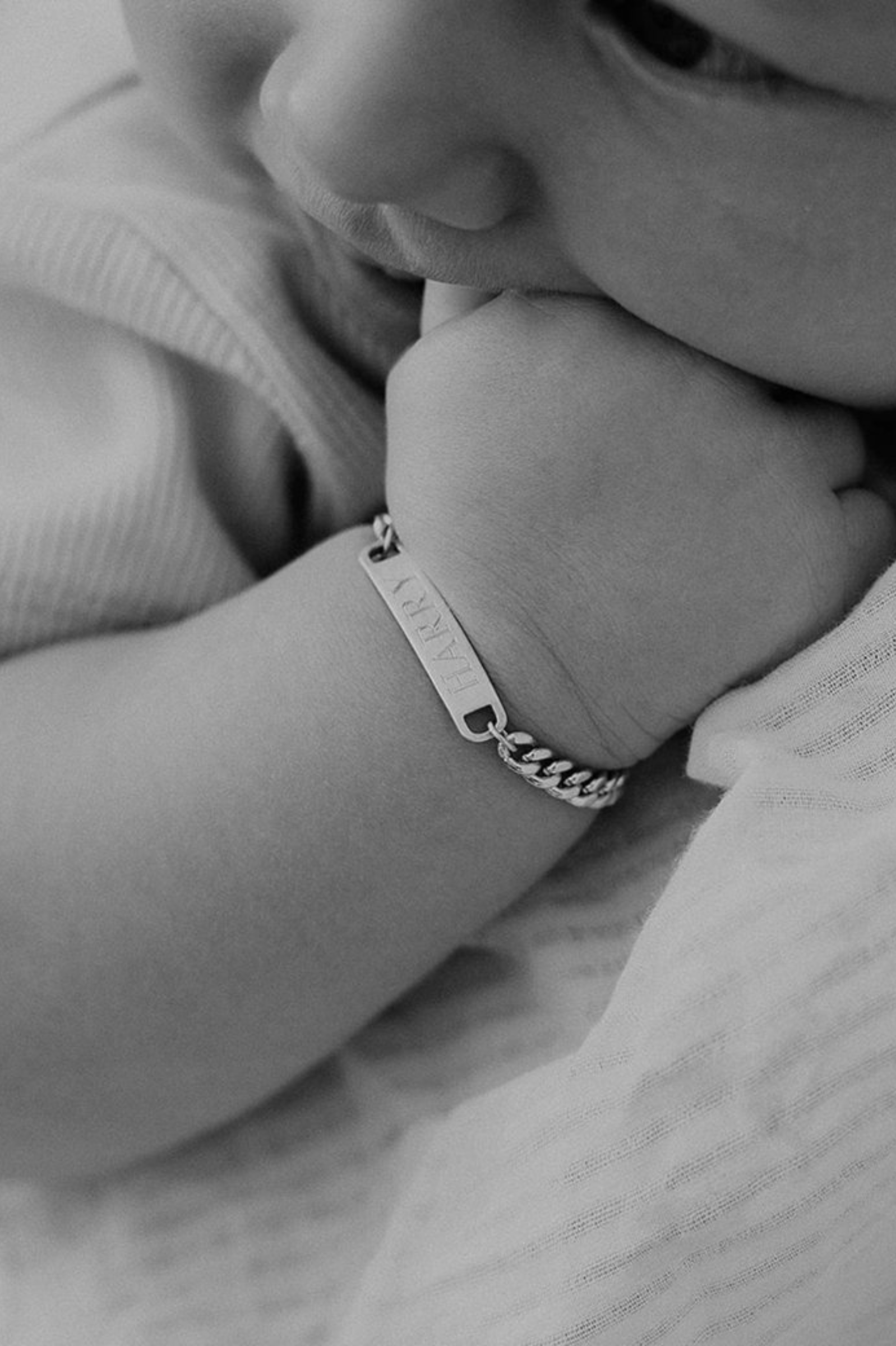 A baby wears a Classic ID Bracelet with personalised engraving on the bar pendant.