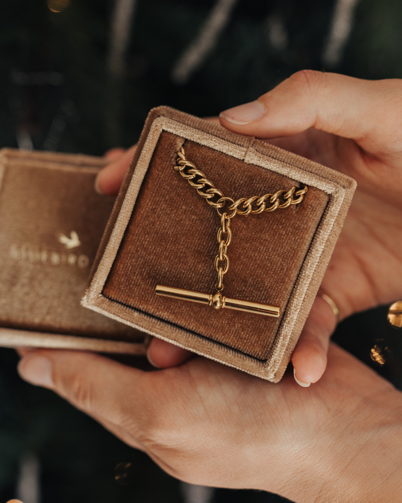 A T-Bar Fob necklace is resting inside a gift box.