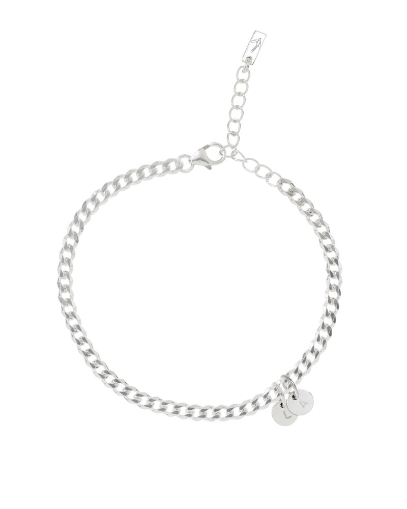 A minimalist silver anklet with round engraved pendants, photographed on a white background to showcase its craftsmanship and simplicity.