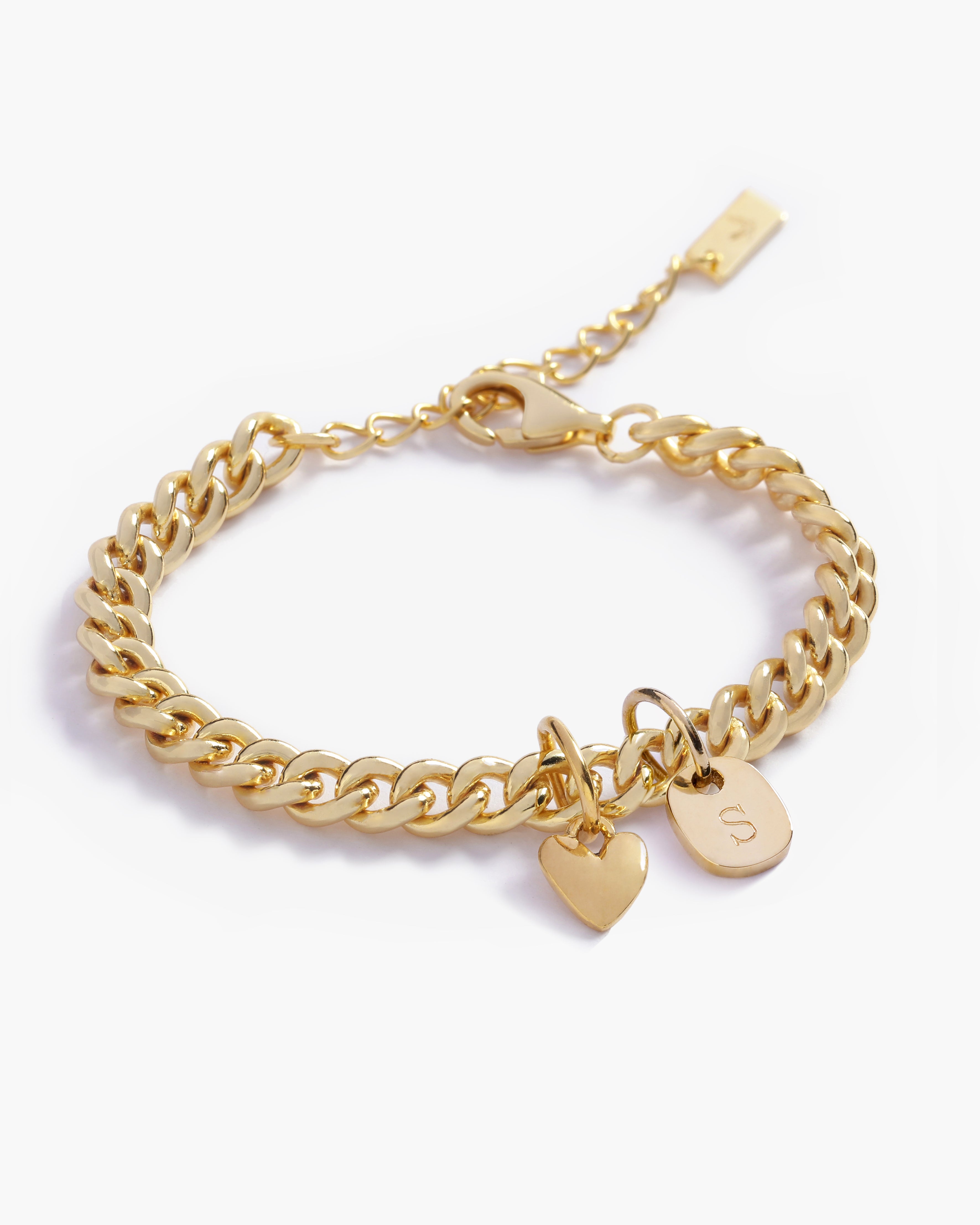 A close-up of a personalised gold bracelet with heart charm and solid gold initial pendant by Bluebird Jewellery