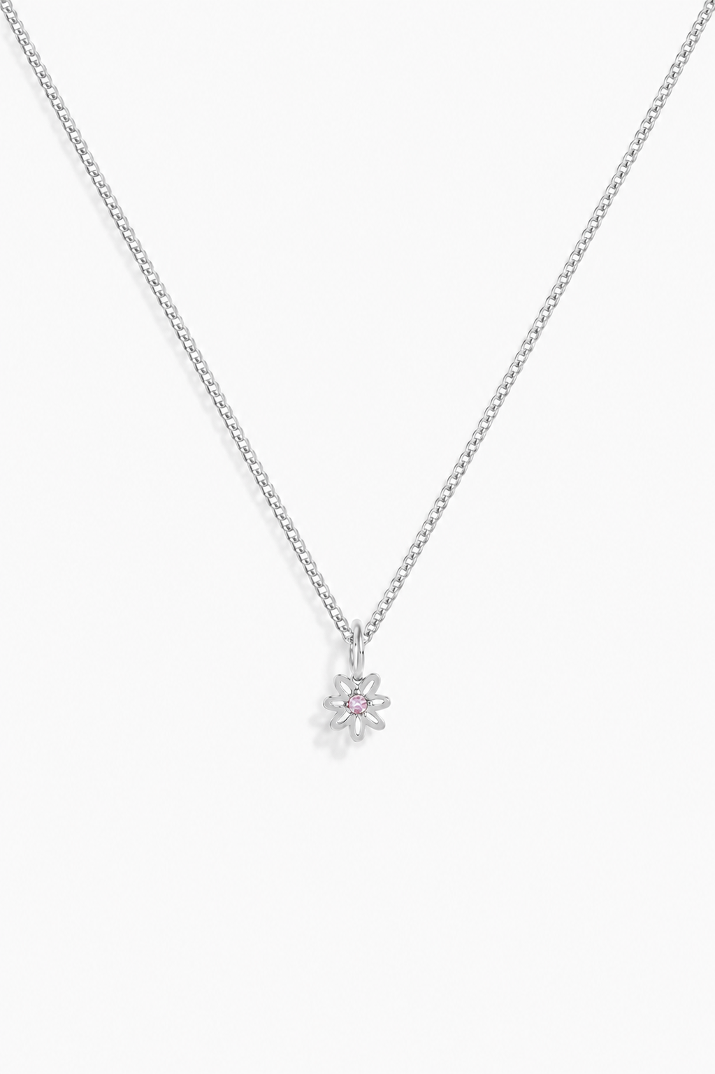 A delicate silver chain necklace with a small flower-shaped pendant featuring a tiny pink gemstone in the center, displayed against a clean white background.