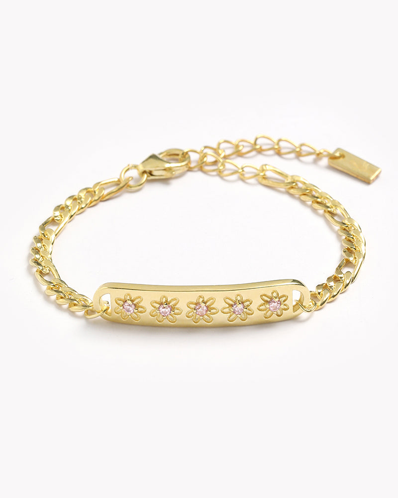 A Gold Daisy bracelet with 5 pink cubic zirconias set within each daisy on the bar pendant of the bracelet by Bluebird Jewellery.