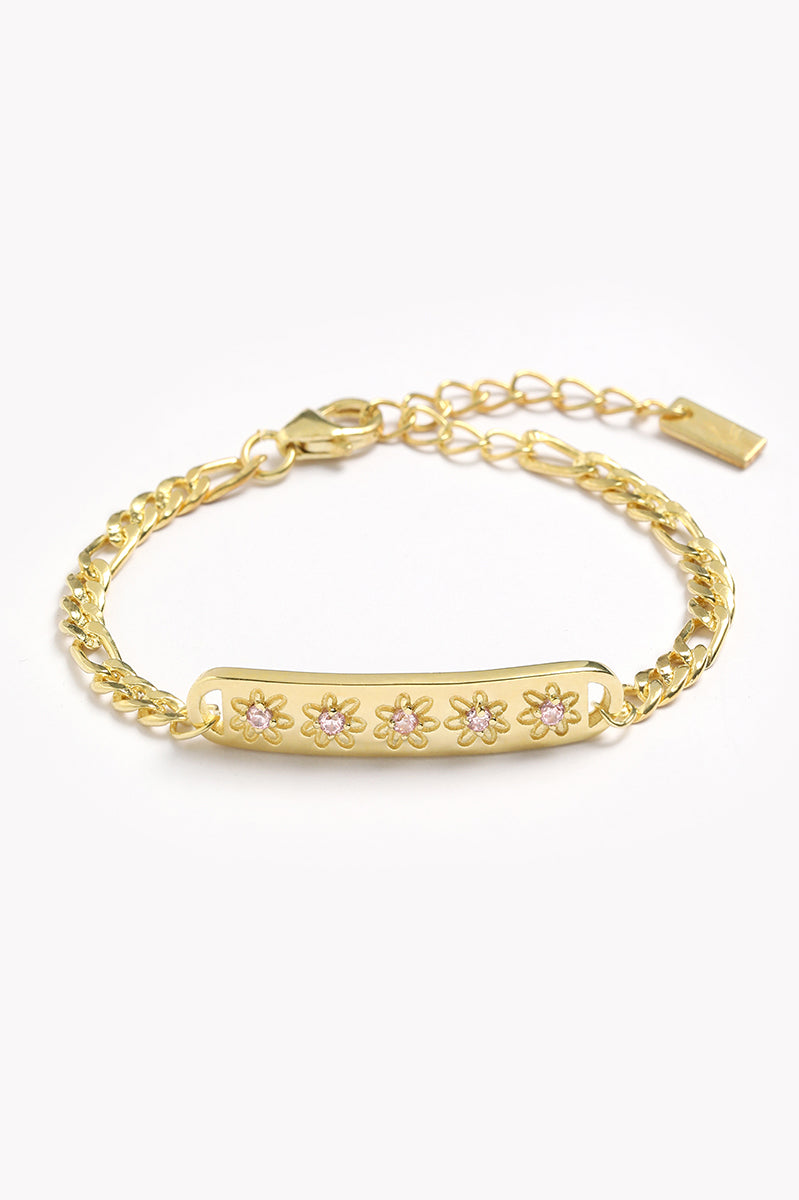 A Gold Daisy bracelet with 5 pink cubic zirconias set within each daisy on the bar pendant of the bracelet by Bluebird Jewellery.