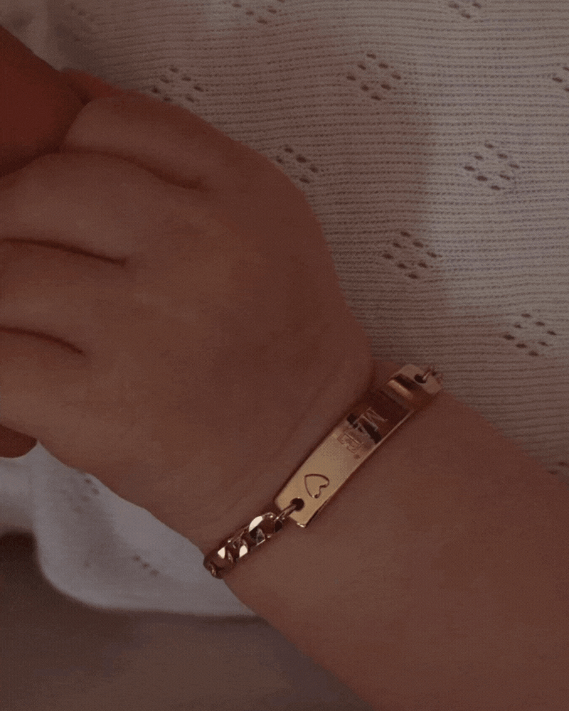 New born baby wearing darling bracelet in gold by Bluebird Jewellery.