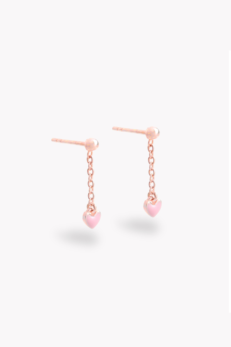 A pair of rose gold drop earrings with pink heart-shaped charms suspended from the drops.