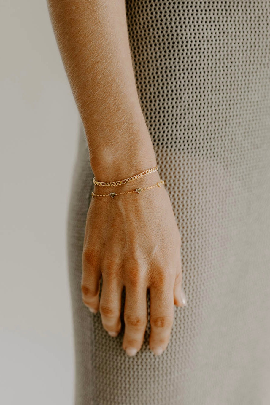 A rose gold figaro bracelet and Rose Gold Heart Bracelet are worn together by Bluebird Jewellery