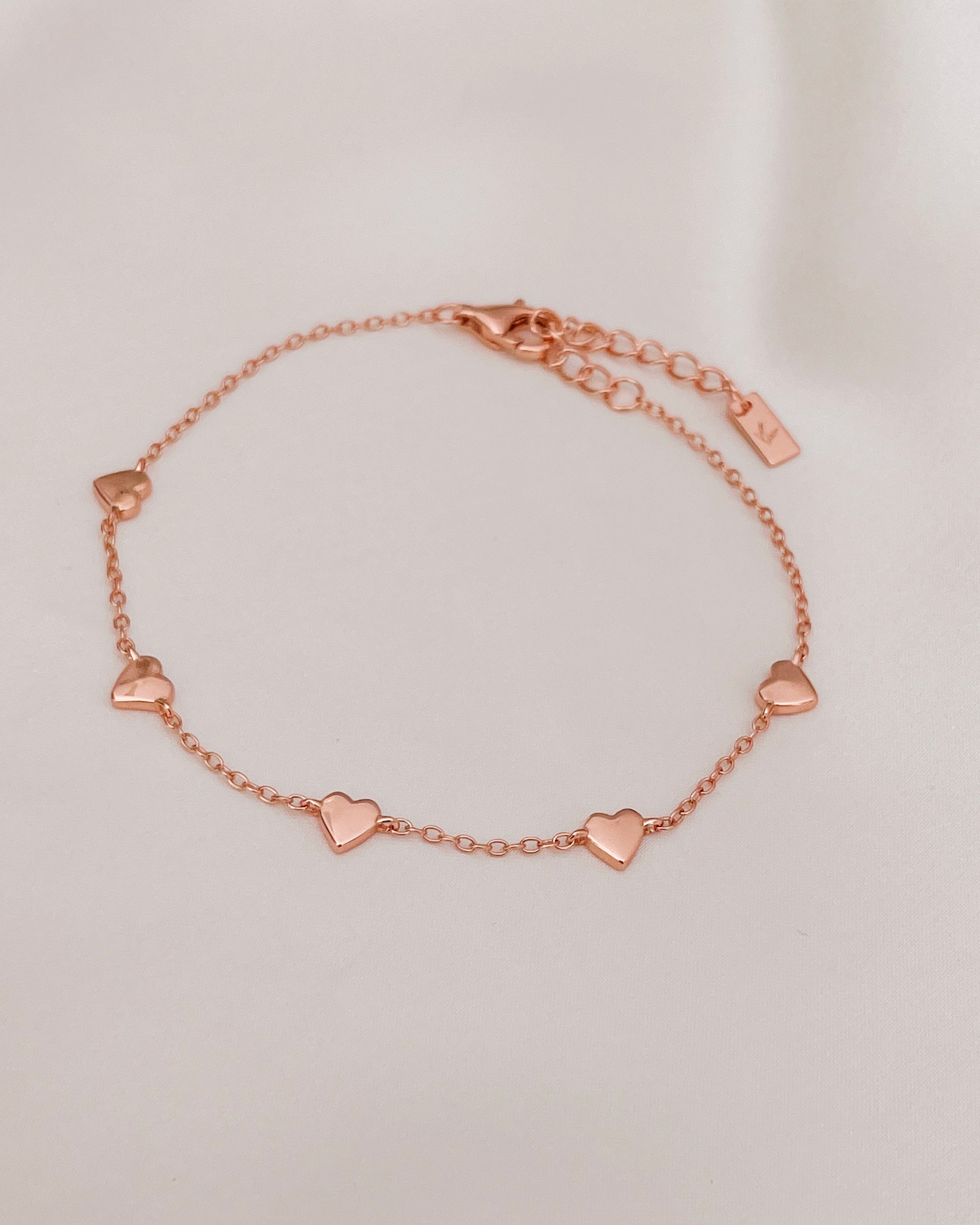 The Bluebird Jewellery Darling Heart Bracelet, featuring five delicate heart motifs in a fine chain, designed as a classic piece for everyday elegance.