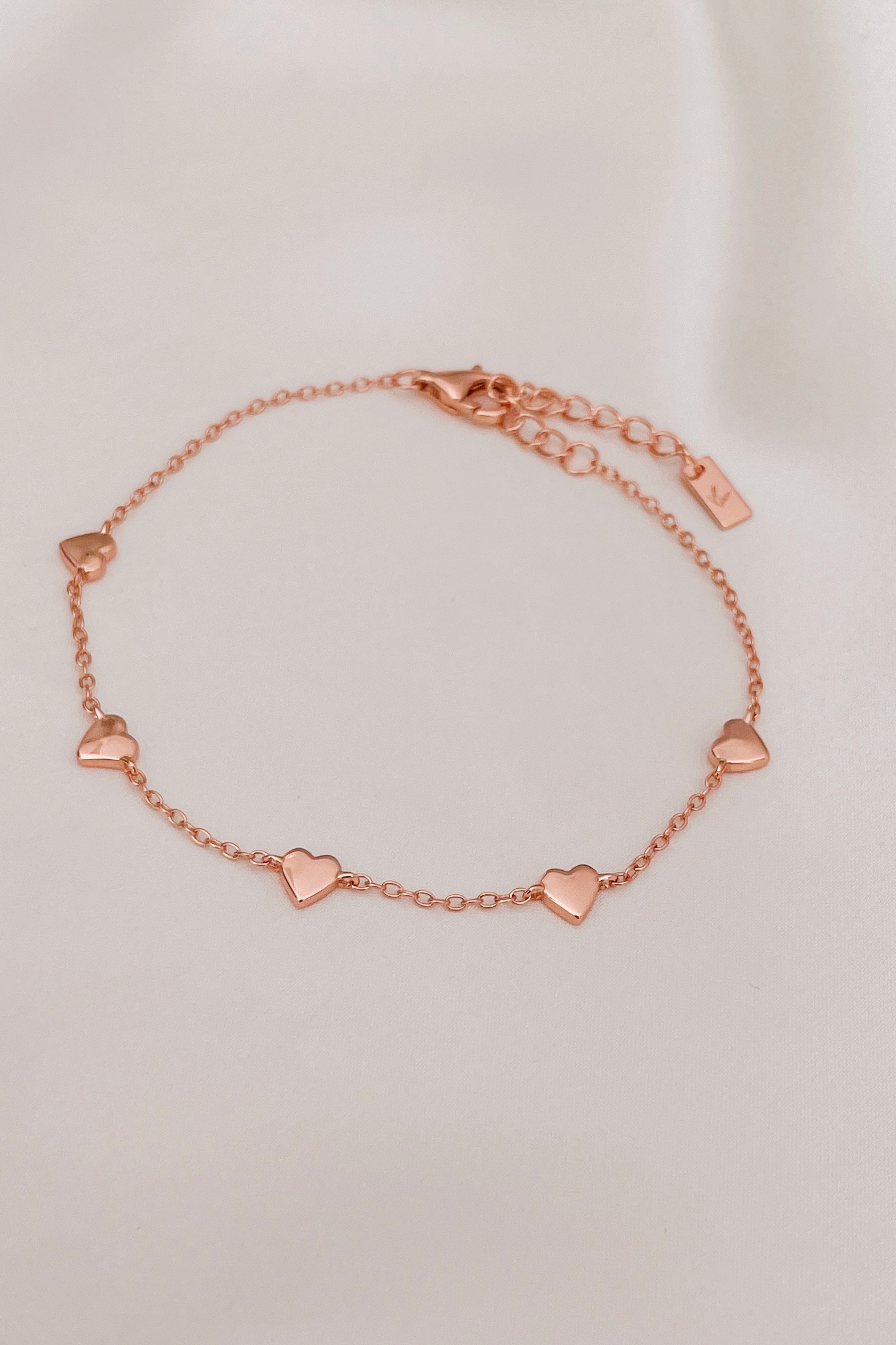 The Bluebird Jewellery Darling Heart Bracelet, featuring five delicate heart motifs in a fine chain, designed as a classic piece for everyday elegance.
