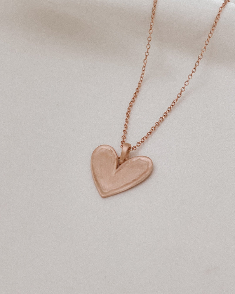 The Darling Necklace in Rose Gold with slightly raised edges and a matte, textured surface.