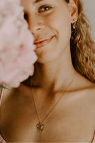 A teenage girl is wearing the Darling Necklace paired with her You Are Loved Earrings both in gold vermeil.