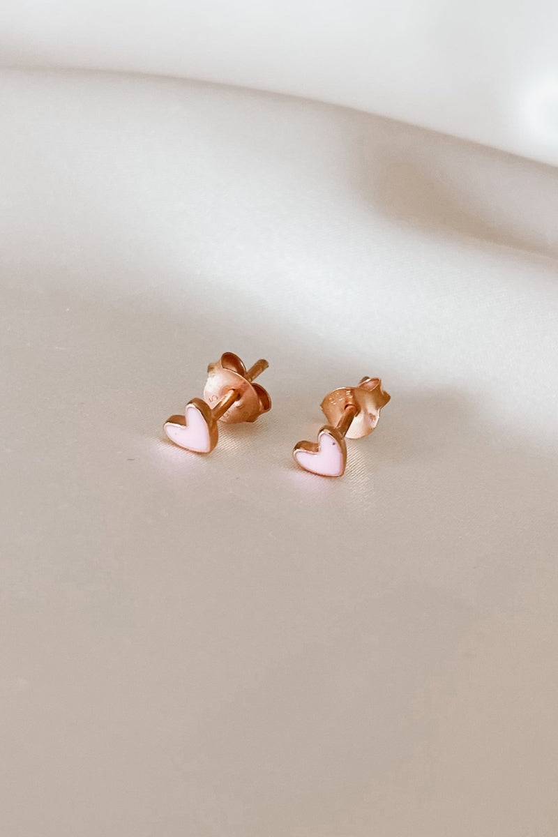 A pair of rose gold Darling stud earrings with heart shapes, designed for children and adults.