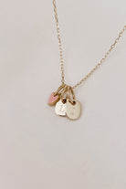 A pink Darling Pendant is on a solid gold chain alongside two mini rectangular pendants also in solid gold