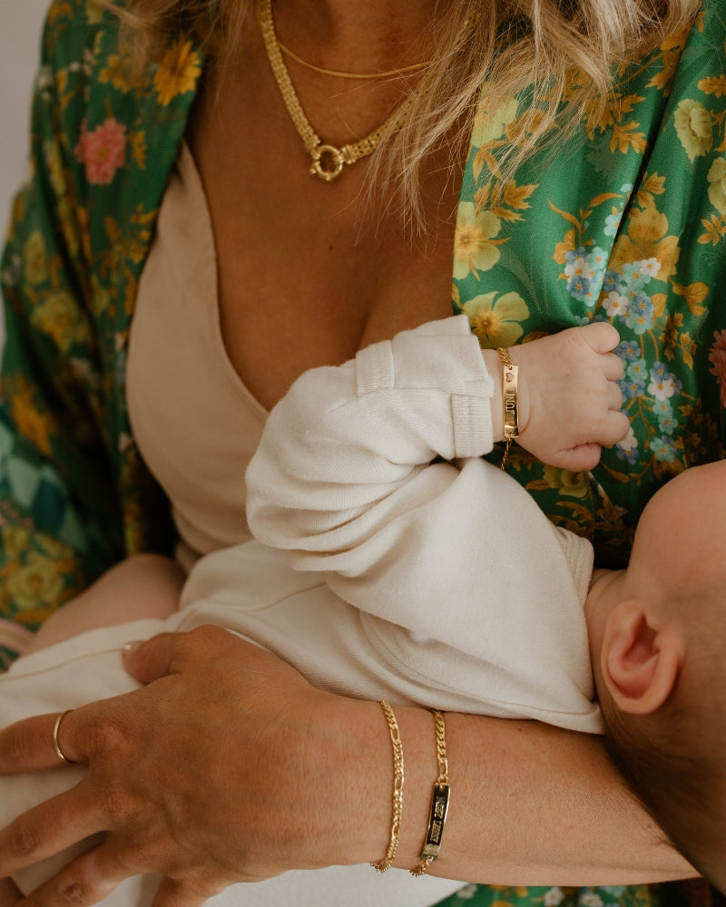 A woman is wearing a Figaro Bracelet alongside a Darling Bracelet by Bluebird Jewellery