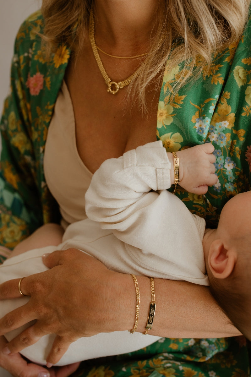 A woman is wearing a Figaro Bracelet alongside a Darling Bracelet by Bluebird Jewellery