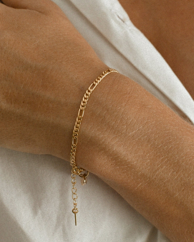 A close-up of the Figaro Bracelet by Bluebird Jewellery, a subtle and elegant gold chain bracelet available in baby, child, and adult lengths.