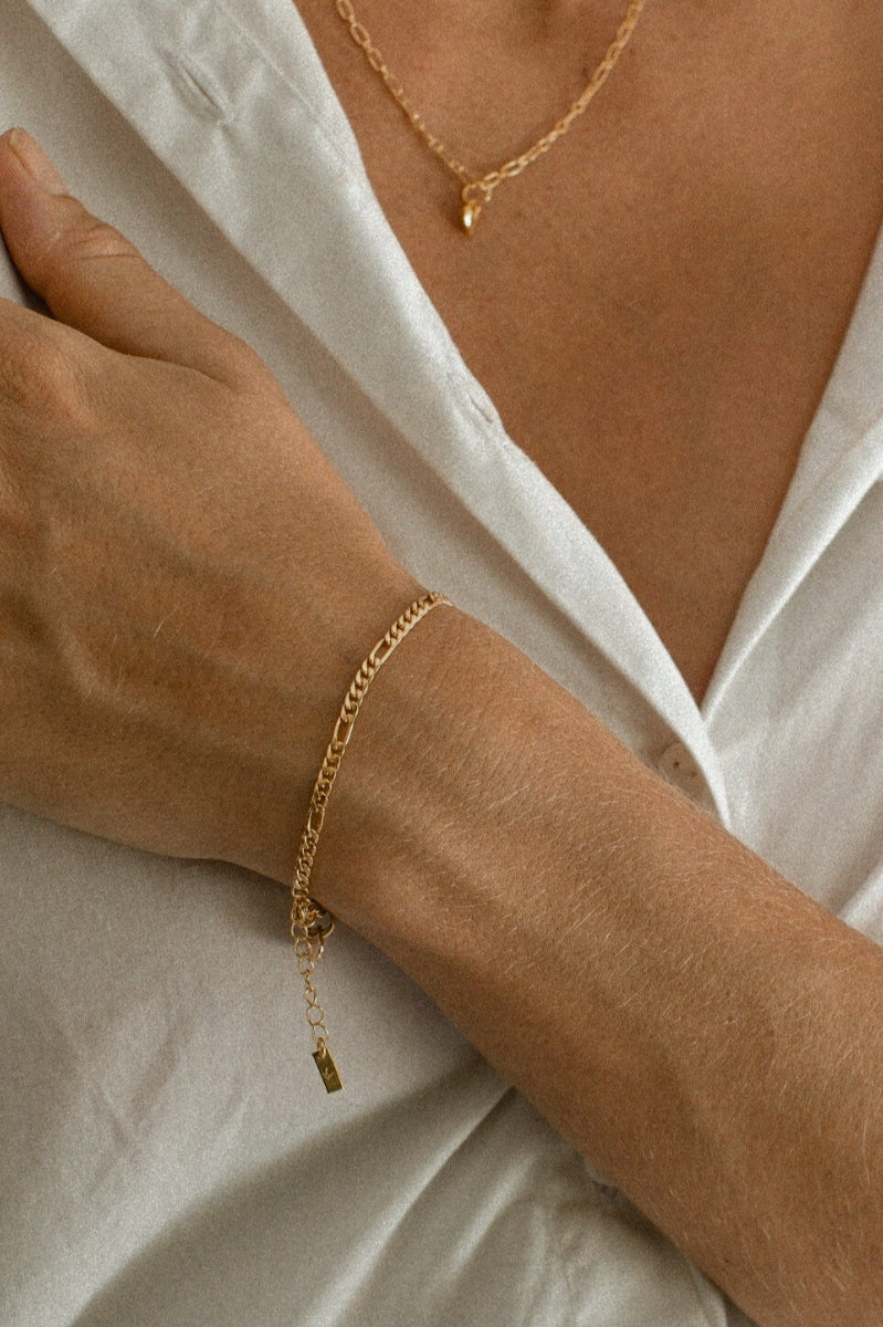 A woman wears Figaro Bracelet in Gold Vermeil.
