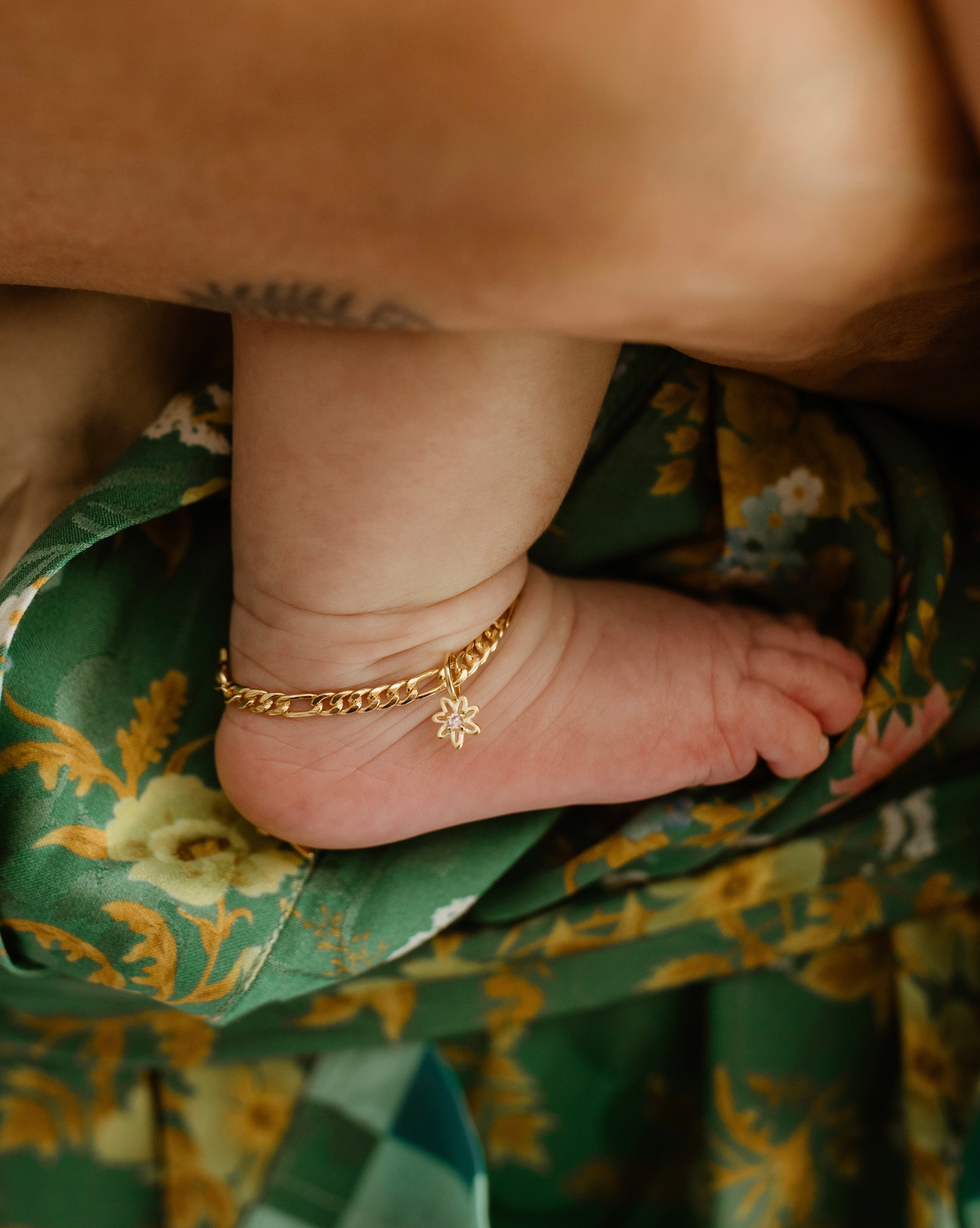 A Newborn Baby wears a newborn sized Figaro Anklet with a