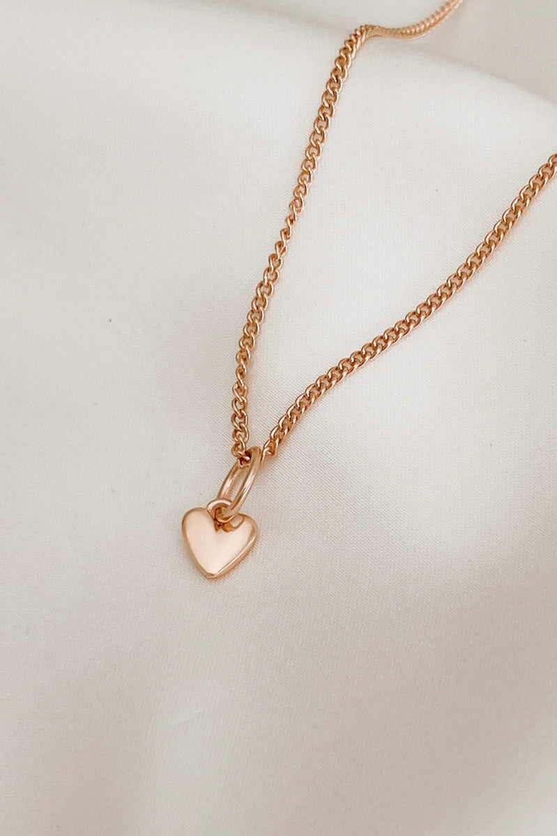 A mini sweetheart pendant is on a rose gold fine curb necklace chain
