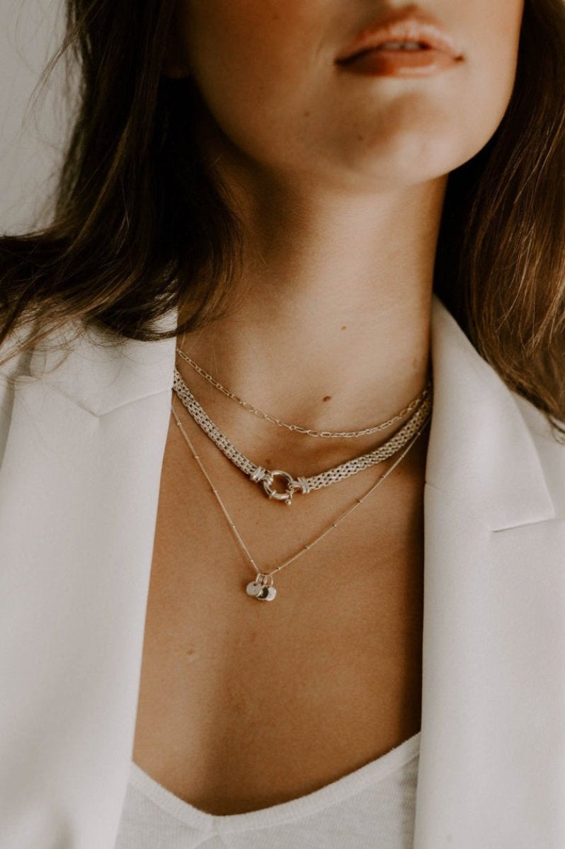 The Petite Initial pendants are shown on a ball chain necklace as part of a series of 3 layered necklaces