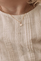 A child wears the 35cm ball chain necklace with a solid 9ct gold initial pendant