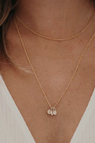 Two ball chain necklaces are worn together.