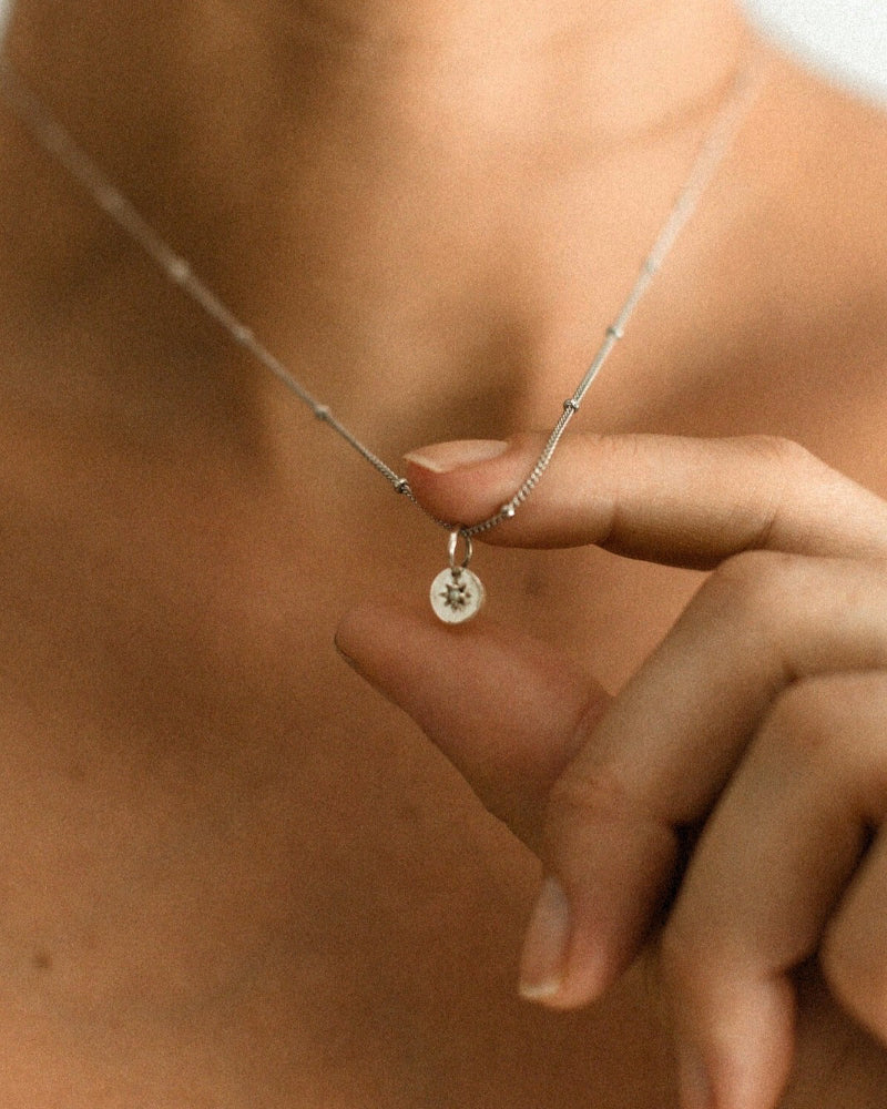 A close up look at the detailing inside the vintage pearl pendant on the ball chain necklace