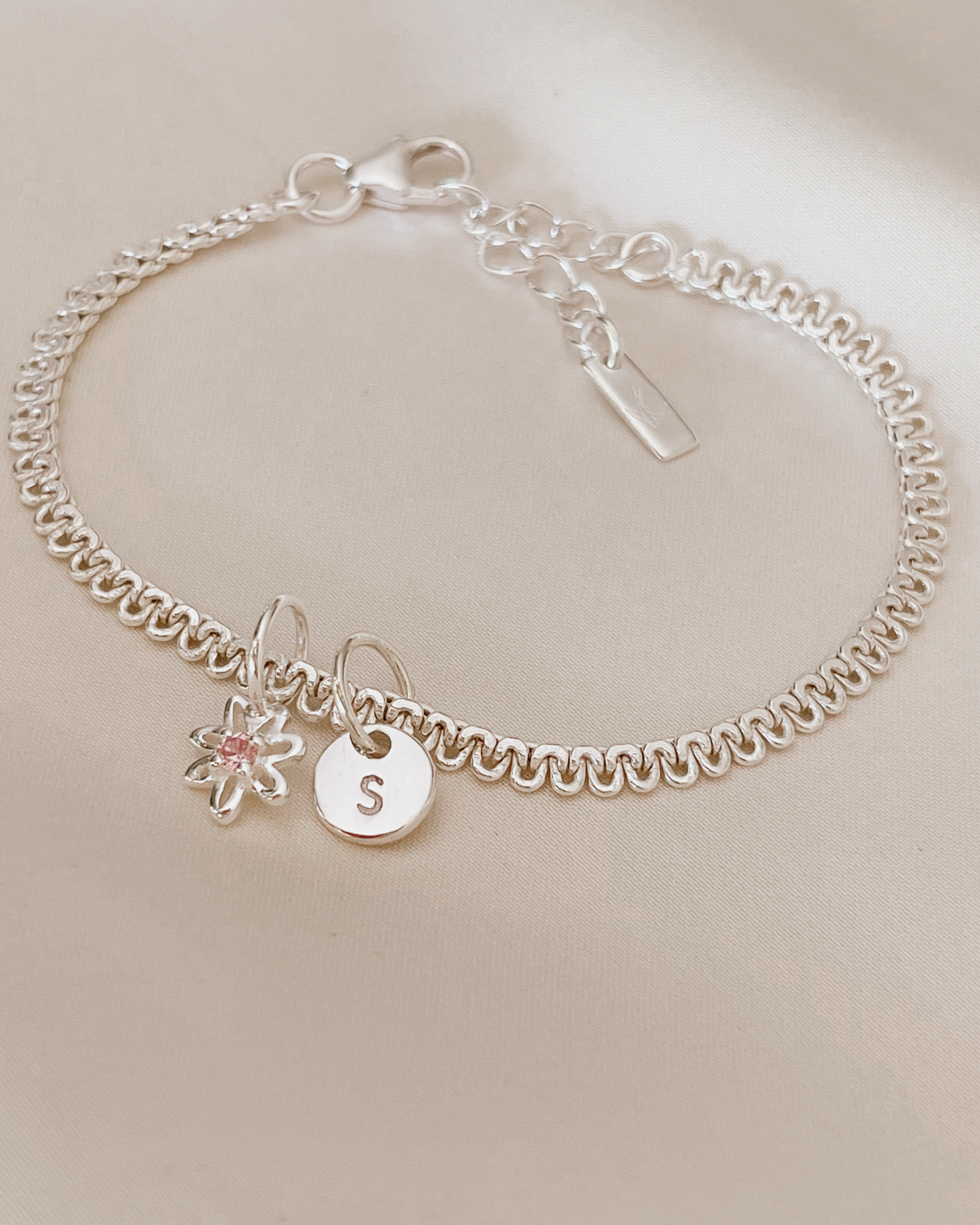 A personalised Lace Chain Bracelet featuring a charm and initial pendant, designed as an elegant fine jewellery gift for all ages.