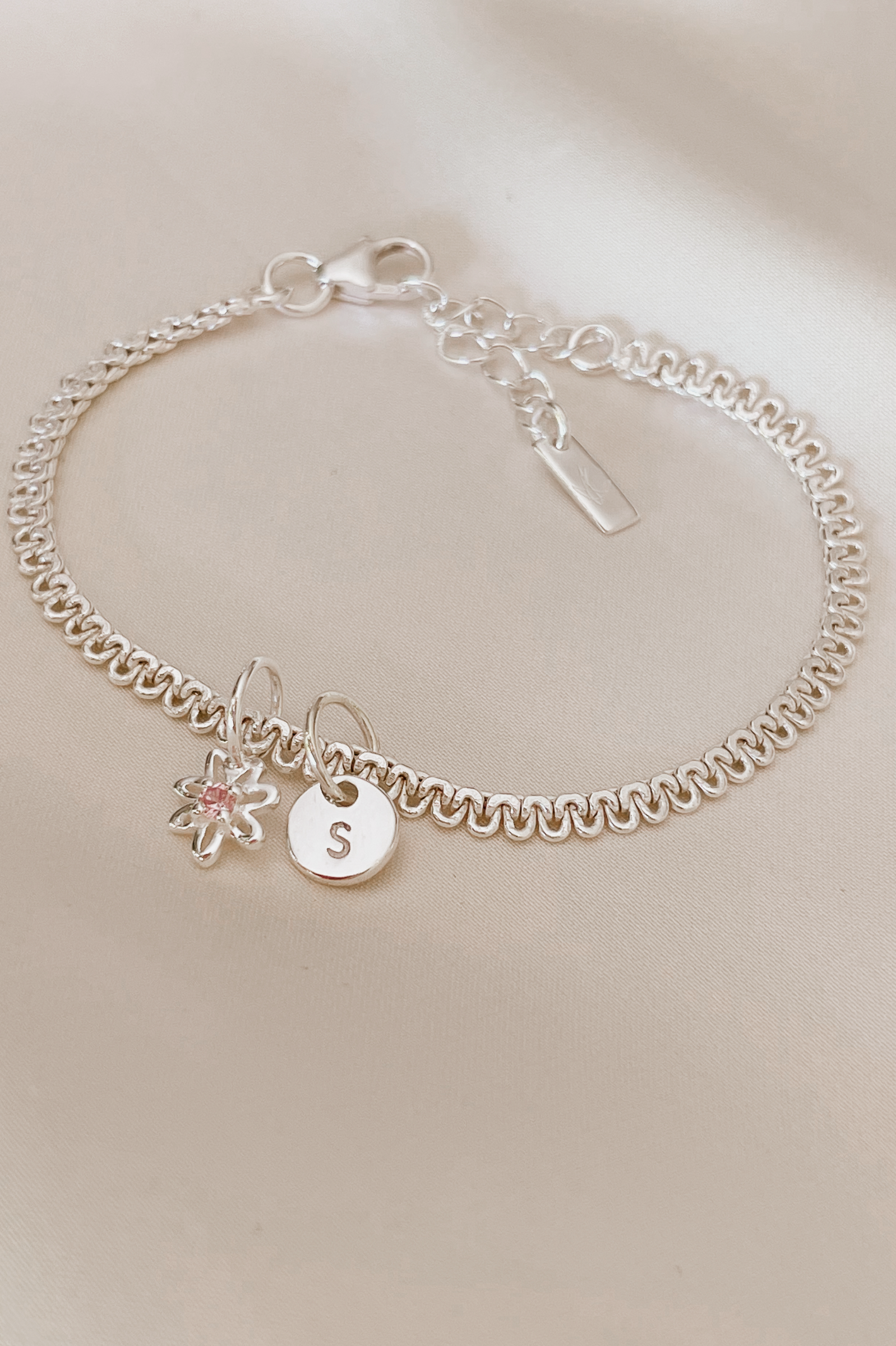 A personalised Lace Chain Bracelet featuring a charm and initial pendant, designed as an elegant fine jewellery gift for all ages.