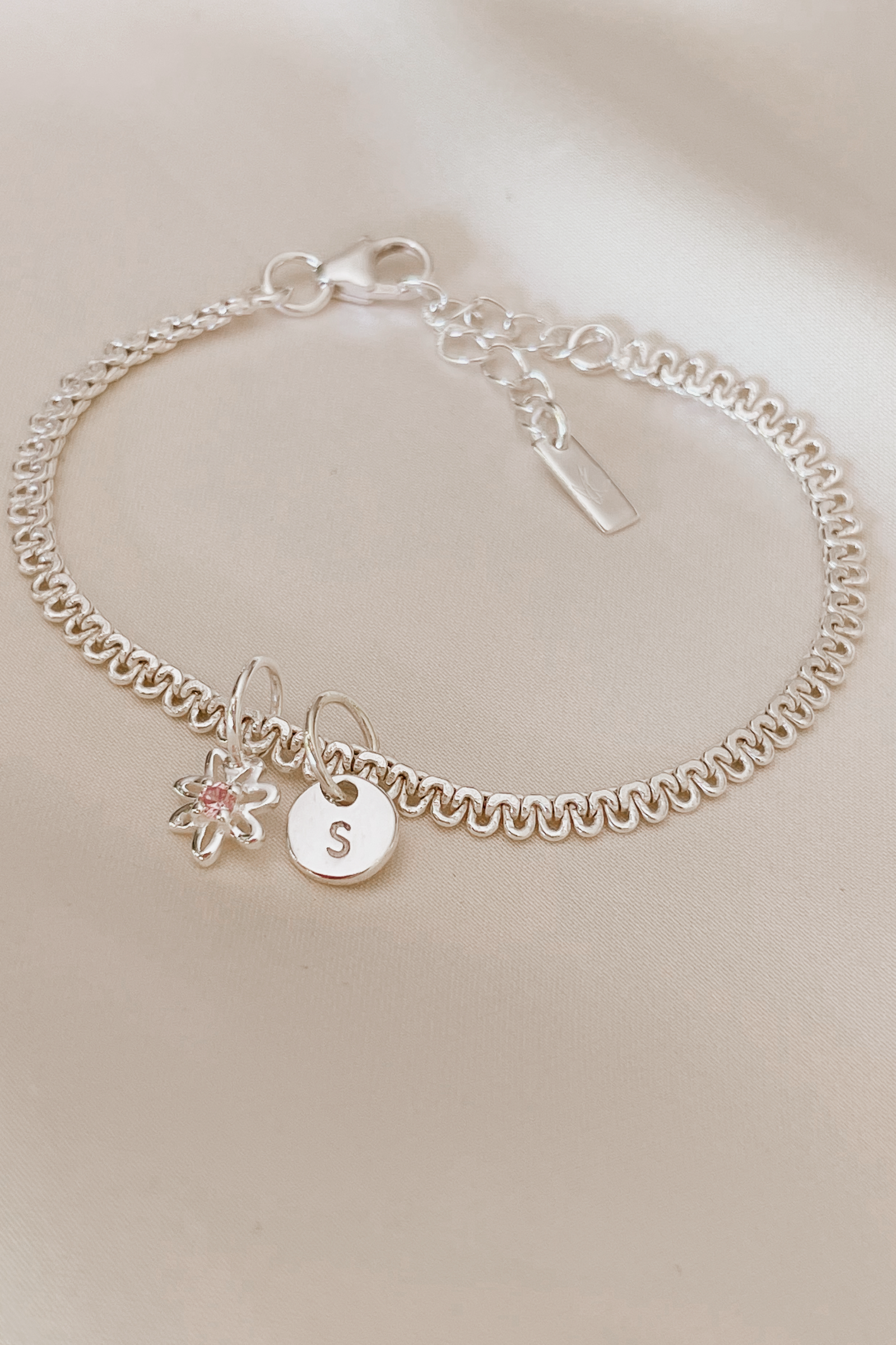 A personalised Lace Chain Bracelet featuring a charm and initial pendant, designed as an elegant fine jewellery gift for all ages.