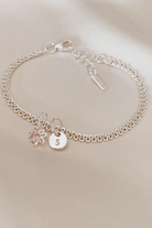 A personalised Lace Chain Bracelet featuring a charm and initial pendant, designed as an elegant fine jewellery gift for all ages.