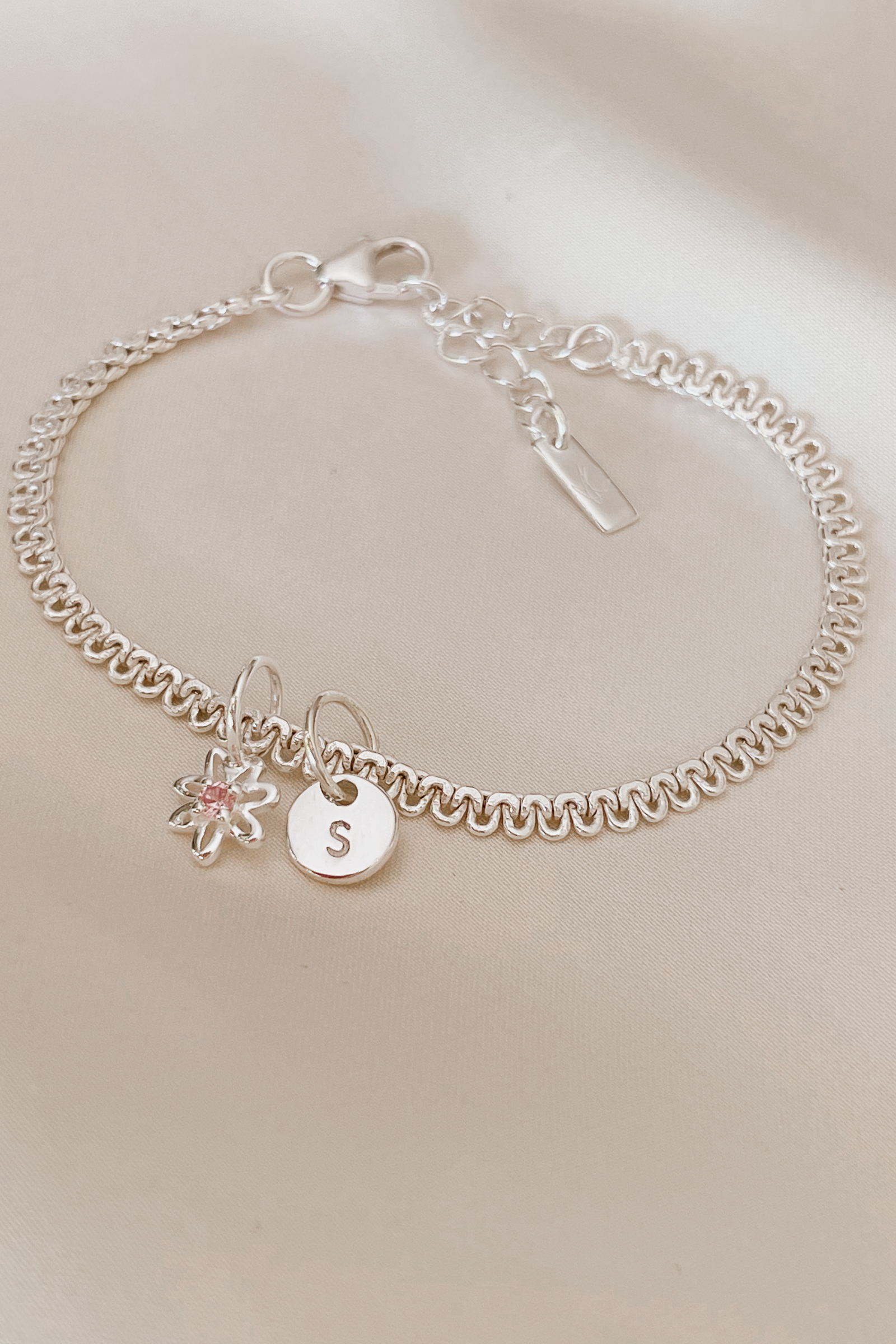 A personalised Lace Chain Bracelet featuring a charm and initial pendant, designed as an elegant fine jewellery gift for all ages.