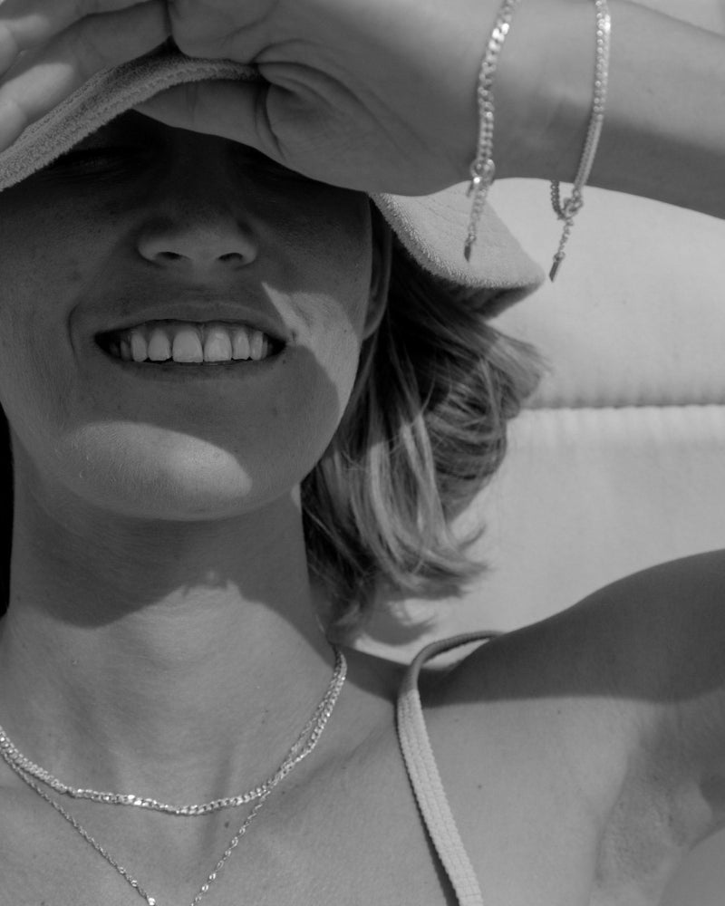 A detailed image capturing a woman wearing matching Lace Chain necklaces and bracelets, crafted as elegant fine silver jewellery by Bluebird Co