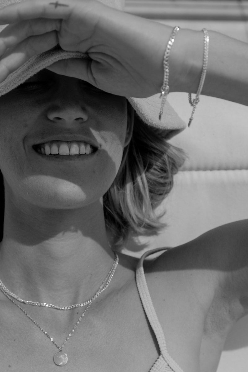 A detailed image capturing a woman wearing matching Lace Chain necklaces and bracelets, crafted as elegant fine silver jewellery.