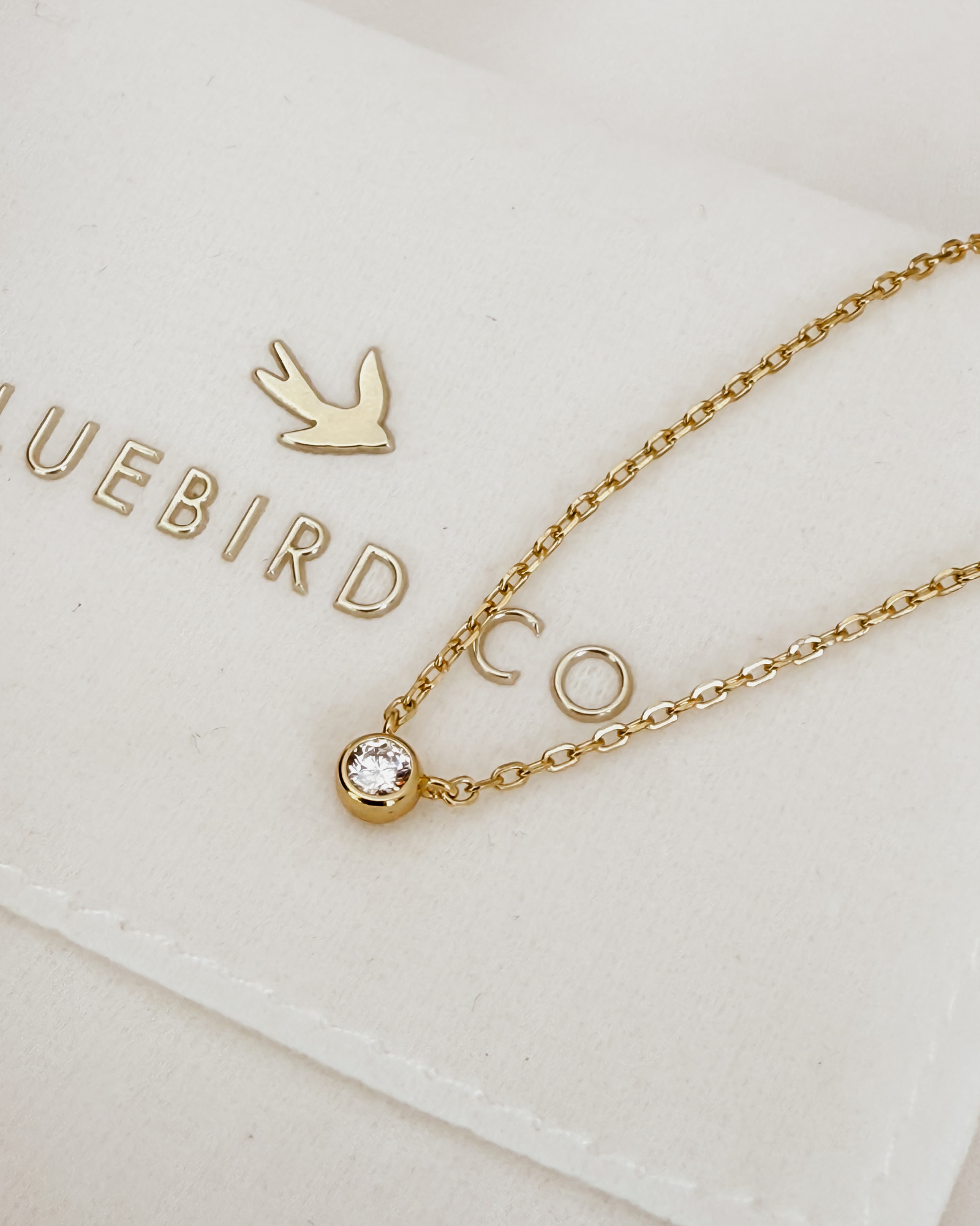 A close-up of the Lumé Necklace by Bluebird Jewellery, inspired by the French word for ‘light,’ crafted as a radiant symbol of warmth and kindness.