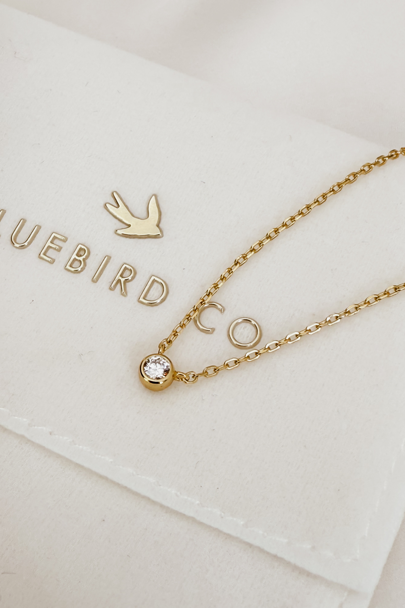 A close-up of the Lumé Necklace by Bluebird Jewellery, inspired by the French word for ‘light,’ crafted as a radiant symbol of warmth and kindness.