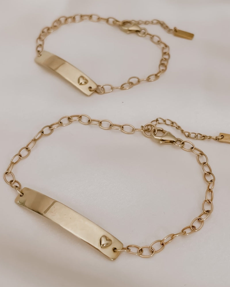 Matching solid gold Darling Bracelets for mum and baby shown flat lay with heart detail and chain link finish by Bluebird Jewellery
