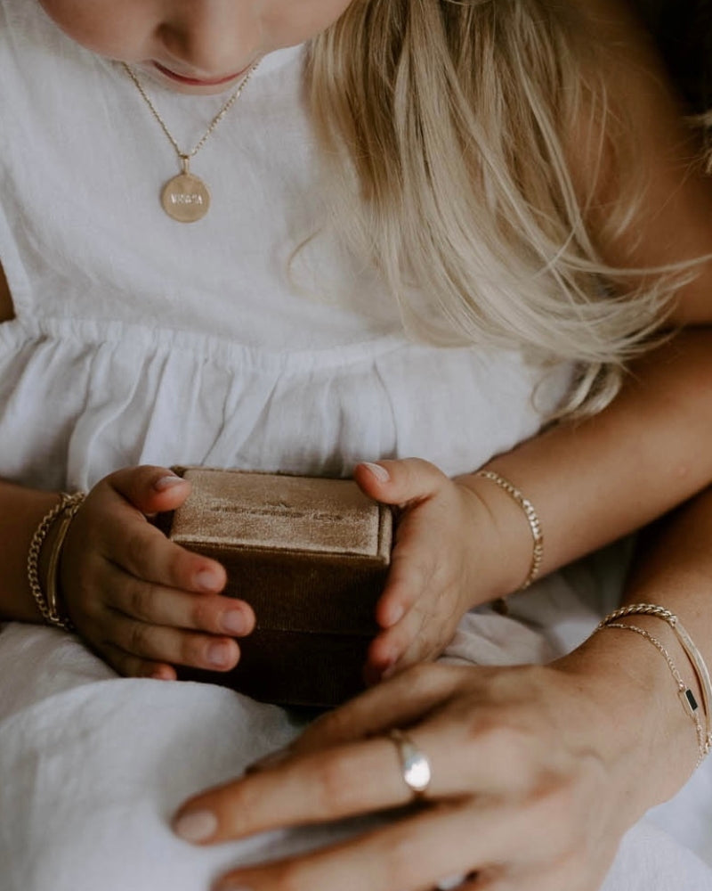 Personalised jewellery gift box is being looked at by a mother and her daughter. The mother and daughter are both wearing matching Bluebird Co Signature Bracelets.