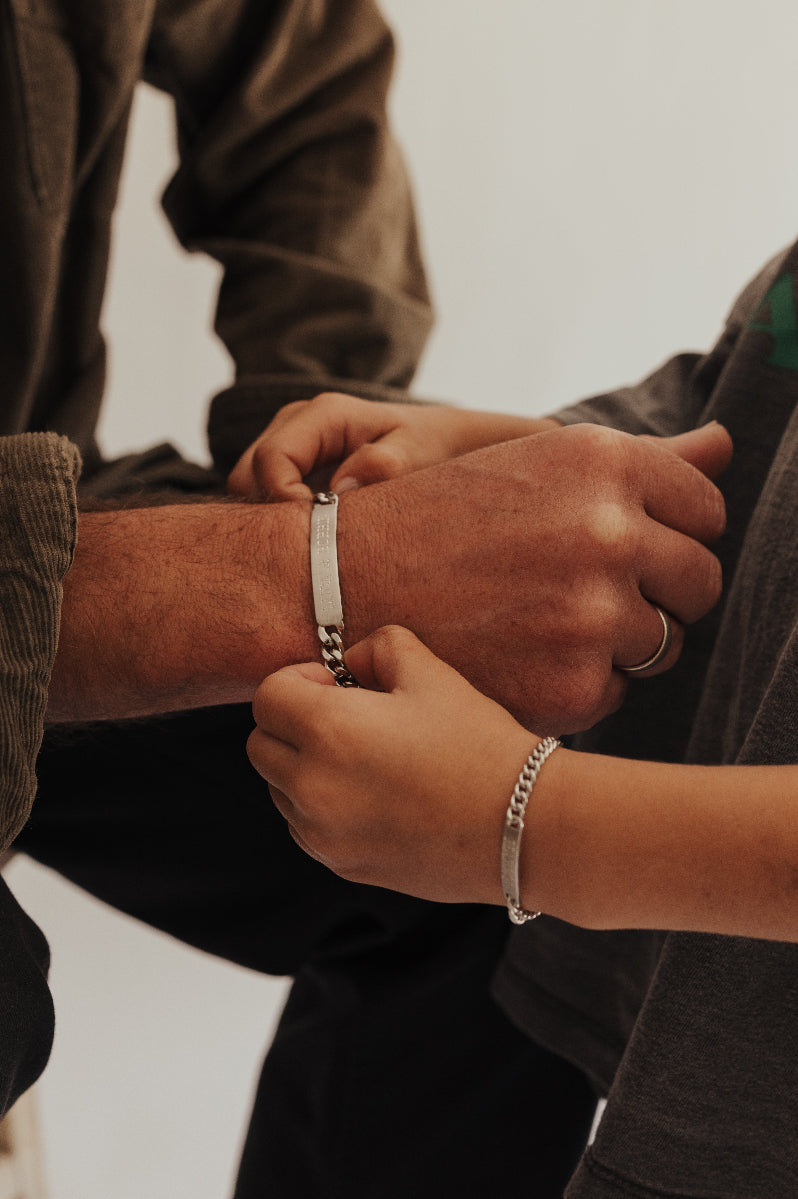 A dad and son wearing matching ID Bracelets by Bluebird Jewellery