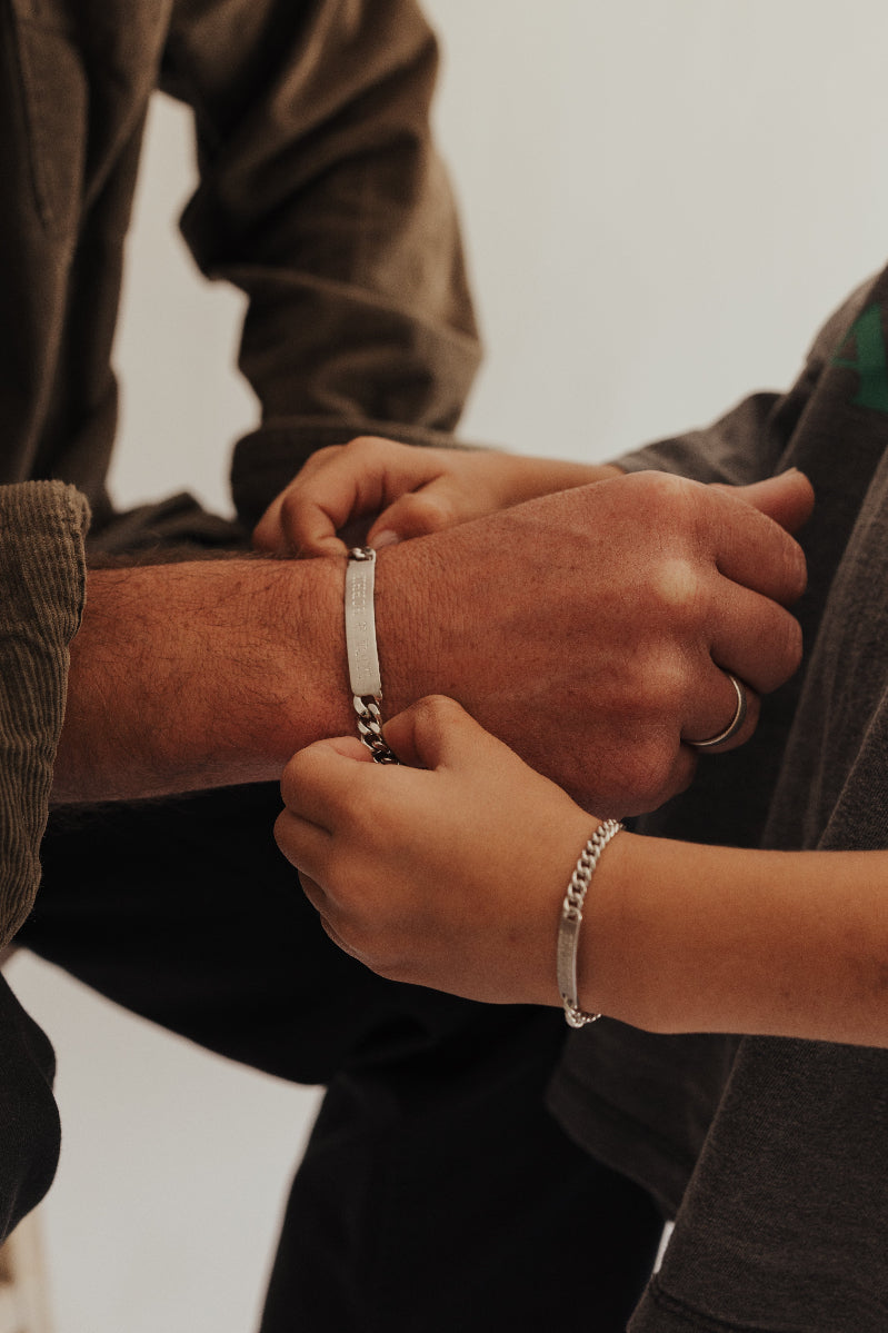 A dad and son wearing matching ID Bracelets by Bluebird Jewellery