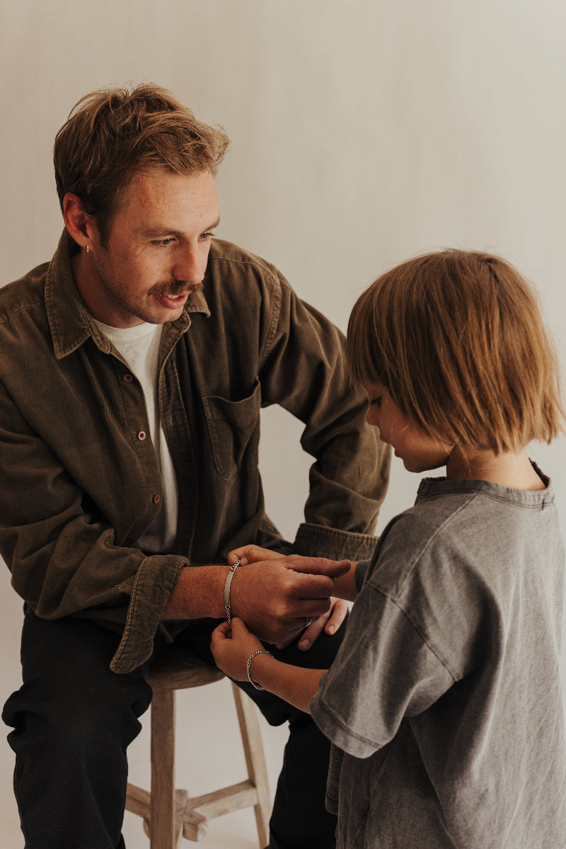 A son giving his dad a bracelet for Father's Day that has personalised engraving on it by Bluebird Jewellery