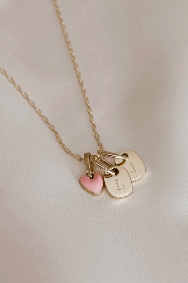 The Mini Rectangular Pendansts with a pink darling pendant on a solid gold chain by Bluebird Jewellery features gentle curves and a luxe, modern silhouette. Personalised with your chosen letter, it embodies feminine elegance and can be worn beautifully on any necklace, bracelet, or anklet chain.