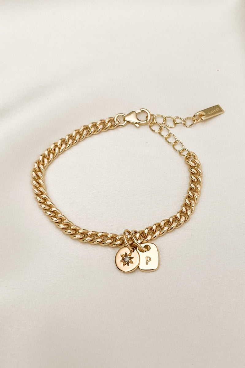 The Cuban Chain bracelet with Daisy pendant and Mini Rectangular Pendant by Bluebird Jewellery features gentle curves and a luxe, modern silhouette. Personalised with your chosen letter, it embodies feminine elegance and can be worn beautifully on any necklace, bracelet, or anklet chain.