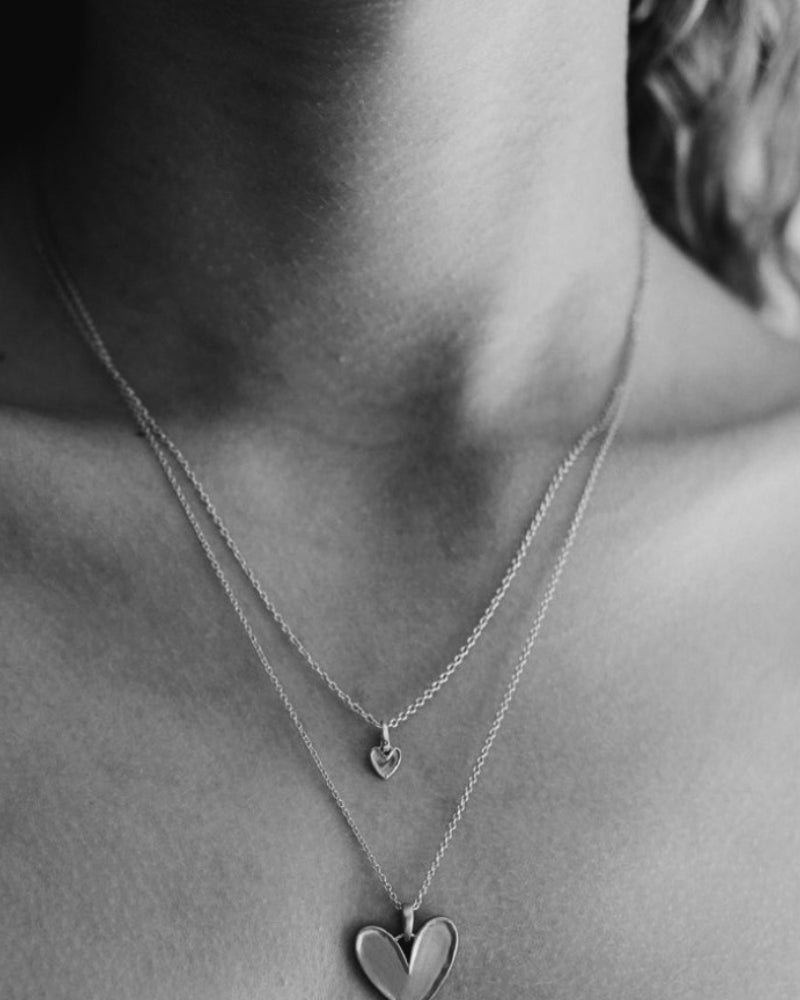 Girl is wearing the Petite Darling Necklace in Silver and layered with the Darling Necklace.
