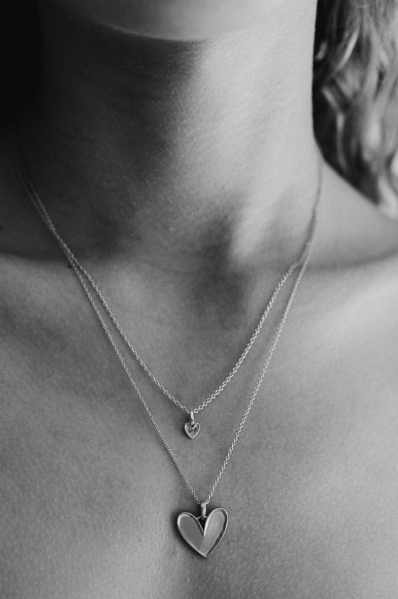 Girl is wearing the Petite Darling Necklace in Silver and layered with the Darling Necklace.