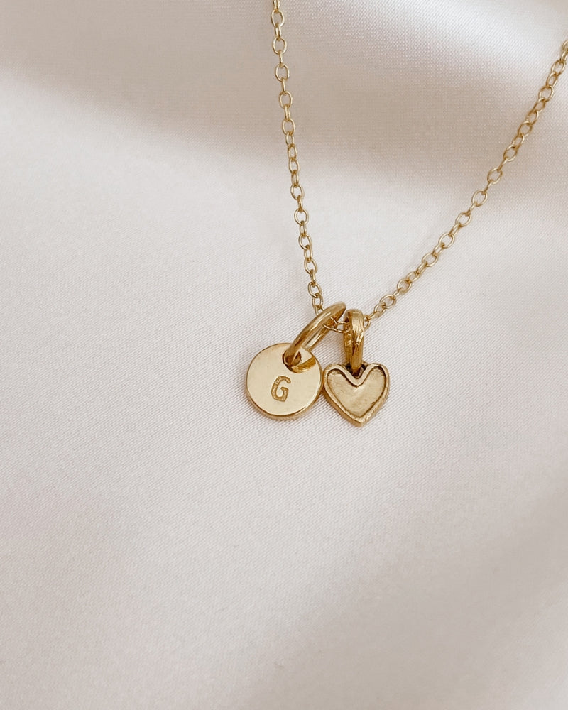 A Petite Darling Necklace with a Petite Initial Pendant in Gold Vermeil added to the necklace. The personalised initial pendant compliments the petite heart shaped pendant.