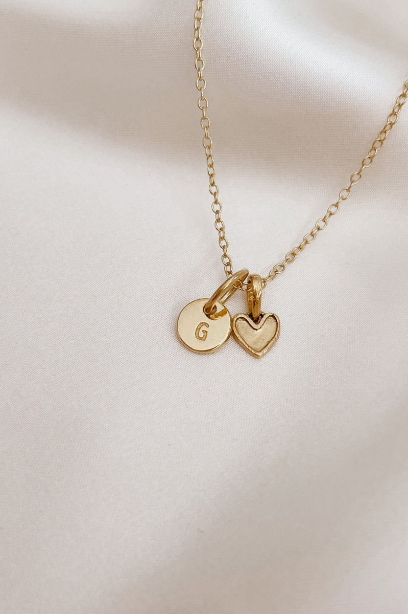 A Petite Darling Necklace with a Petite Initial Pendant in Gold Vermeil added to the necklace. The personalised initial pendant compliments the petite heart shaped pendant.
