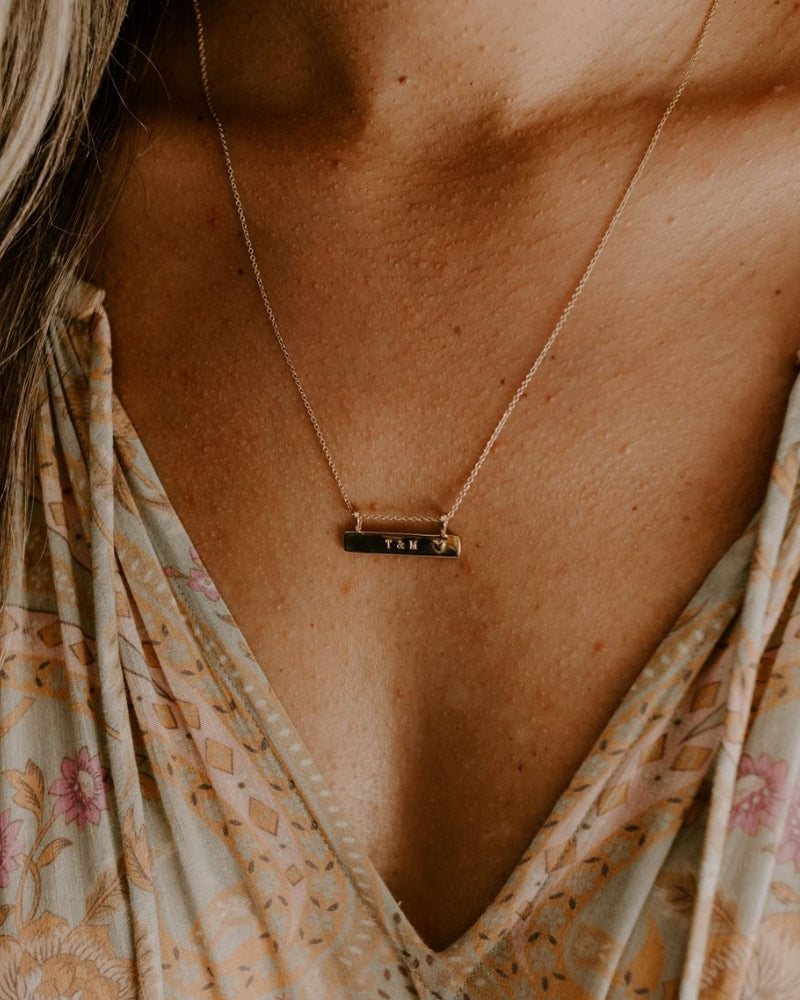 A Darling Bar Necklace has personalised engraving on the front surface and is worn at the 45+5cm length.