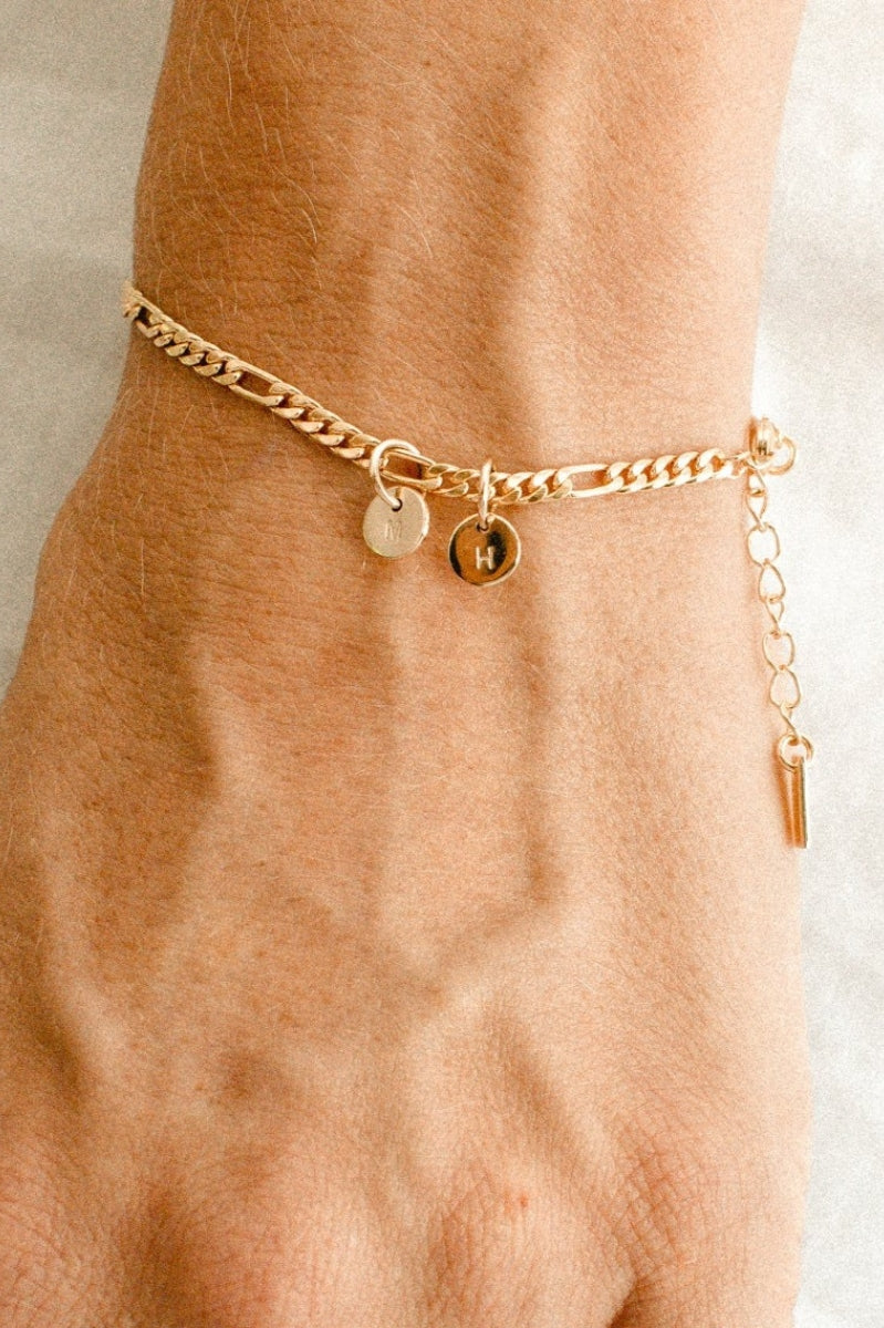 A figaro chain bracelet with a classic round Petite Gold Vermeil Initial Pendants from Bluebird Jewellery, personalised with your chosen letter and designed to be worn elegantly on any necklace, bracelet, or anklet chain.